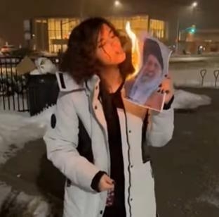 이란 최고지도자 사진으로 담뱃불 붙이는 이란 여성. 사진=연합뉴스