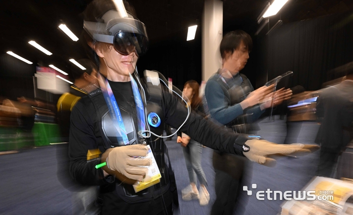 세계 최대 가전·정보기술(IT) 전시회 'CES 2026'이 오는 6일부터 나흘 간 미국 네바다주 라스베이거스 일대에서 열린다. 개막을 이틀 앞둔 4일(현지시간) 라스베이거스 만달레이베이 컨벤션센터에서 열린 CES 언베일드(Unveiled)에서 참관객이 비햅틱스의 택슈트프로와 택글러브를 체험하고 있다.  라스베이거스=이동근기자 foto@etnews.com