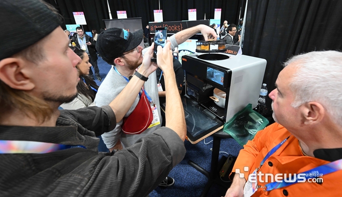 세계 최대 가전·정보기술(IT) 전시회 'CES 2026'이 오는 6일부터 나흘 간 미국 네바다주 라스베이거스 일대에서 열린다. 개막을 이틀 앞둔 4일(현지시간) 라스베이거스 만달레이베이 컨벤션센터에서 열린 CES 언베일드(Unveiled)에서 참관객이 노쉬 로보틱스의 쿠킹로봇을 살펴보고 있다.  라스베이거스=이동근기자 foto@etnews.com