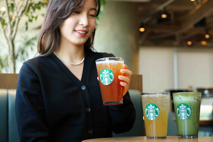 모델이 스타벅스의 티 음료를 살펴보고 있다.
