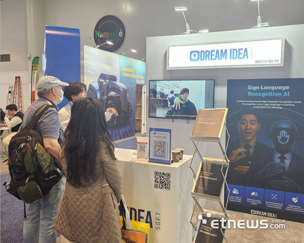 'CES 2026' 드림아이디어소프트 부스에서 관람객들이 AI 기반 수어 인식 배리어프리 키오스크에 대해 설명을 듣고 있다.