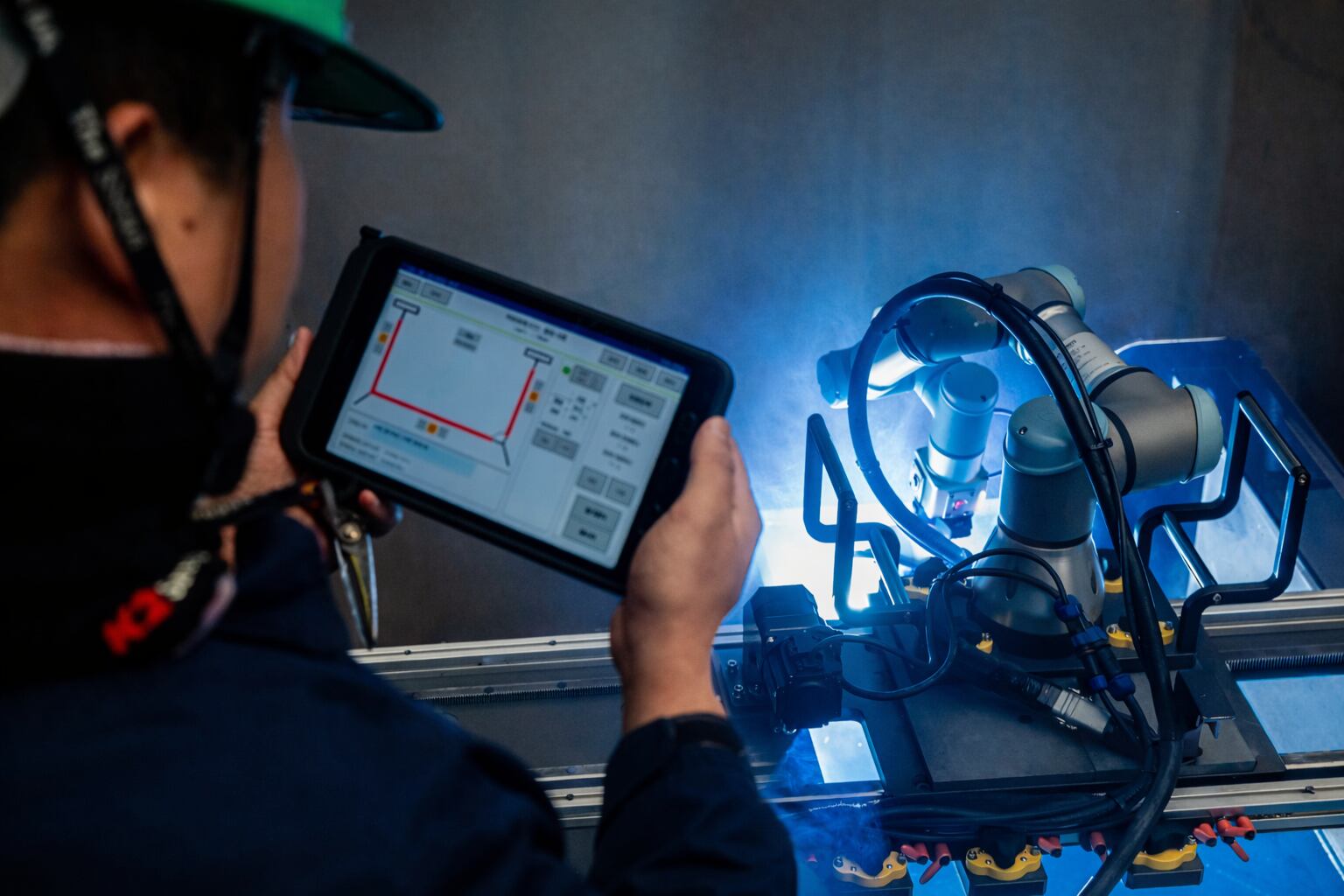 지난 7일 울산 남구 HD현대중공업 용연공장에서 작업자가 태블릿PC로 용접할 셀의 데이터를 불러온 뒤 로봇에 작업을 지시한 모습./HD현대중공업