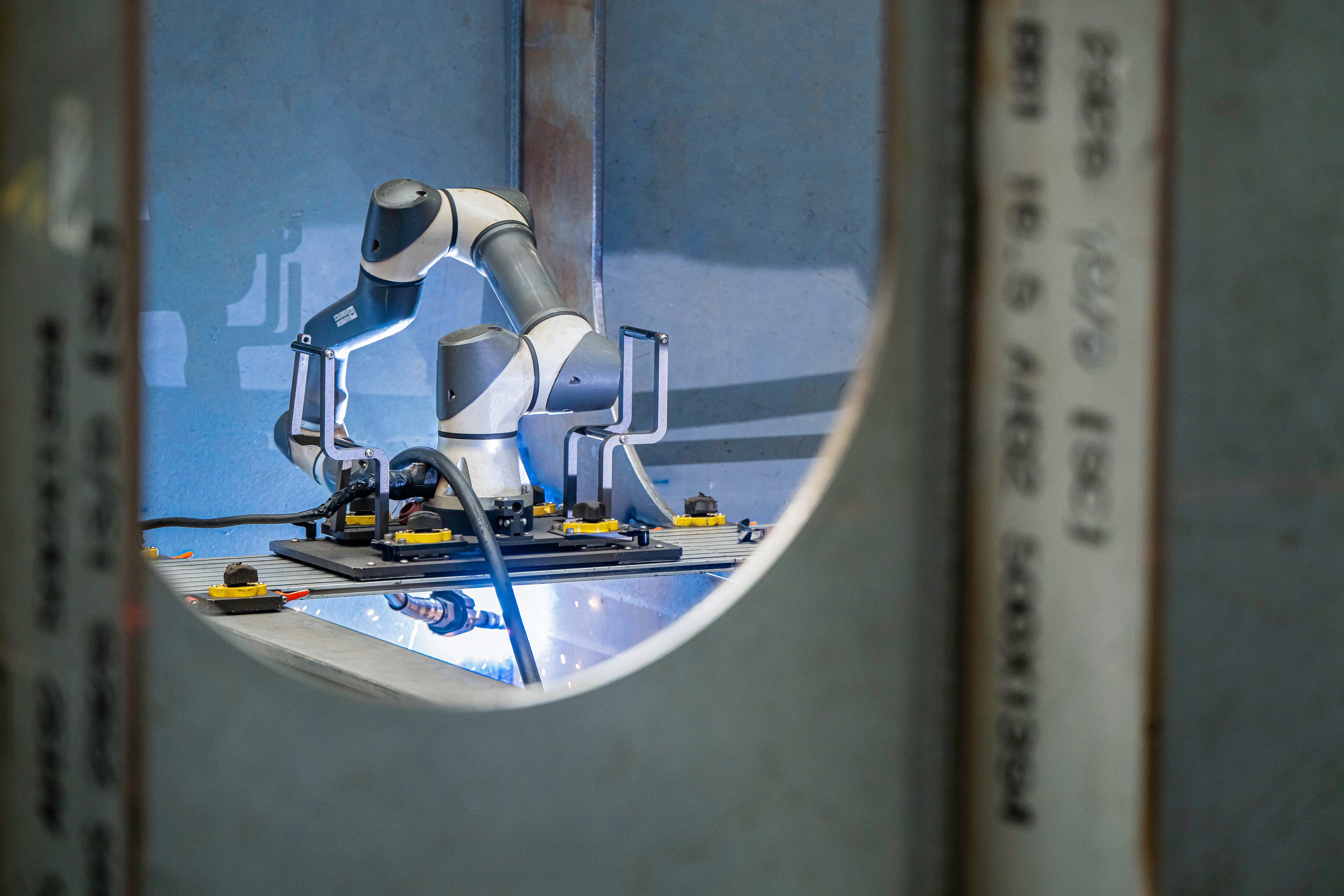 지난 7일 울산 남구 HD현대중공업 용연공장에서 사람 팔 모양의 로봇이 선박 블록 접합부를 용접하고 있는 모습./HD현대중공업 