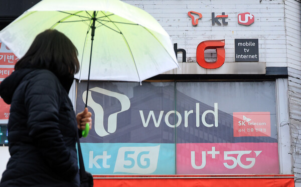 한 시민이 2025년 12월 23일 오후 서울의 한 휴대폰 매장 앞을 지나가고 있다. / 뉴스1