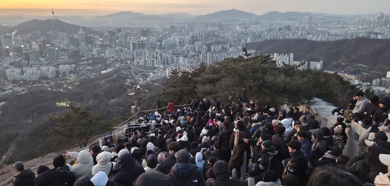 Citizens wait for the sunrise atop Inwang mountain in Seoul on Thursday. (Yonhap)