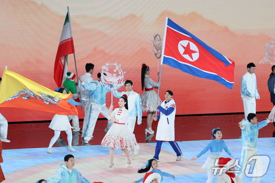 North Korean athlete Han Kum-chol carries the North Korean flag during the closing ceremony of the 9th Asian Winter Games held at the Harbin International Convention and Exhibition Sports Center in Heilongjiang Province, China, on February 14, 2025. 2025.2.14 / News1