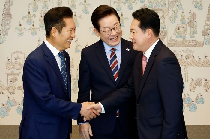 이재명 대통령이 지난해 9월 8일 서울 용산 대통령실 청사에서 열린 여야 지도부 오찬 회동에서 정청래 더불어민주당 대표와 장동혁 국민의힘 대표의 악수 모습을 보며 밝게 웃고 있다. ⓒ뉴시스