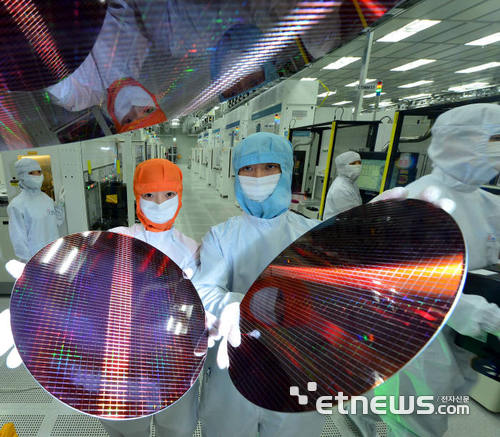 반도체 회사 직원들이 메모리 반도체 웨이퍼를 들어보이고 있다.