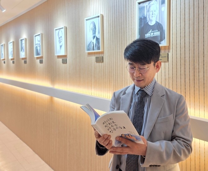 권건우 대표가 '야사와 만화로 배우는인공지능' 책을 보고 있다. 이 책은 서울데이터과학연구회의 성과로 많은 사람들이 관심을 보이고 있다.