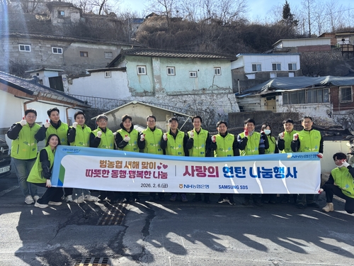 6일 서울 서대문구 홍제동 일대 연탄 나눔 행사에 참석한 김주식 NH농협은행 AI데이터부문 부행장과 직원들이 삼성SDS 임직원들과 함께 기념 촬영을 하고 있다.(사진=농협은행)