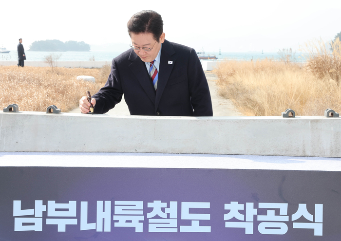 이재명 대통령이 6일 경남 거제시 견내량 인근에서 열린 남부내륙철도 착공식에서 침목에 서명하고 있다. 연합뉴스
