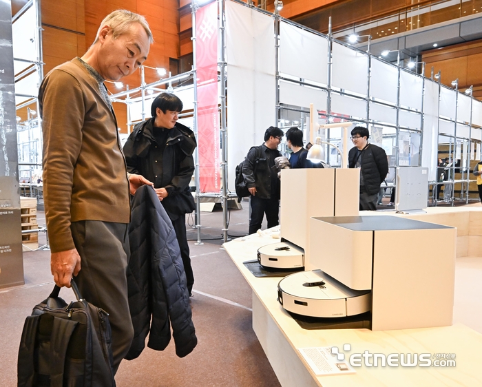 13일 서울 강남구 코엑스에서 열린 디자인코리아에서 참관객이 삼성전자의 AI물걸레 로봇청소기 '비스포크AI 스팀90 시리즈'를 살펴보고 있다. 이동근기자 foto@etnews.com 2025.11.13