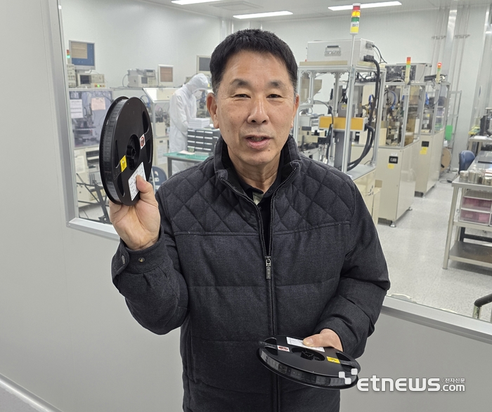 김정희 에이치엔에스하이텍 대표가 디스플레이 소재인 수정발진기를 들어보이고 있다.