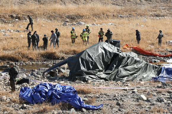 &nbsp;  Military authorities investigate the crash site of an Army Cobra helicopter in Hyeon-ri, Jojeong-myeon, Gapyeong County, Gyeonggi Province on July 9. [Photo: Yonhap News]