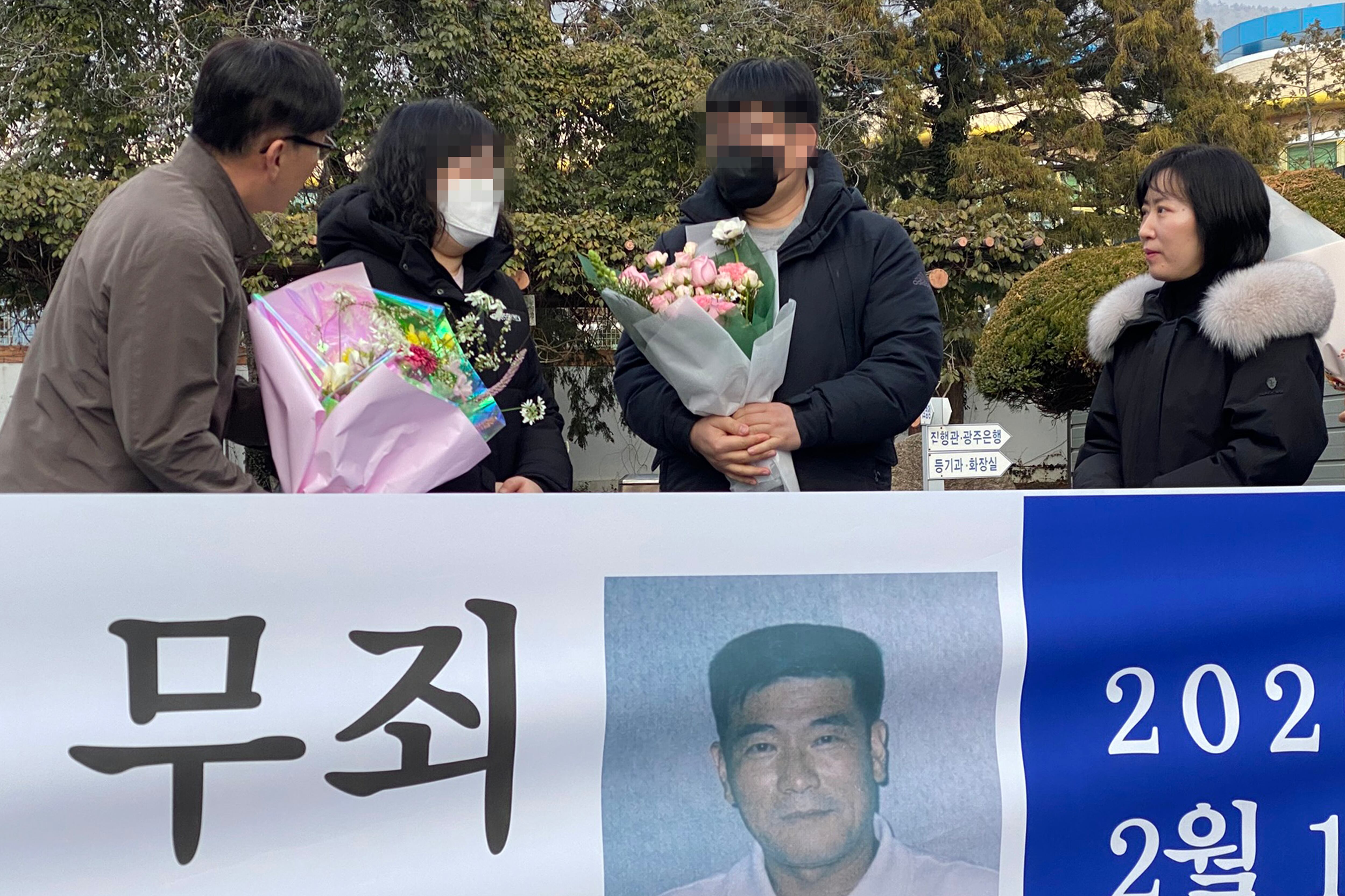 11일 오후 전남 해남군 해남읍 광주지법 해남지원 법정 앞에서 보험금을 노려 아내를 살해한 혐의로 무기징역을 받았던 고(故) 장 씨의 유족이 재심 무죄 선고에 따른 축하 꽃다발을 받고 있다./연합뉴스