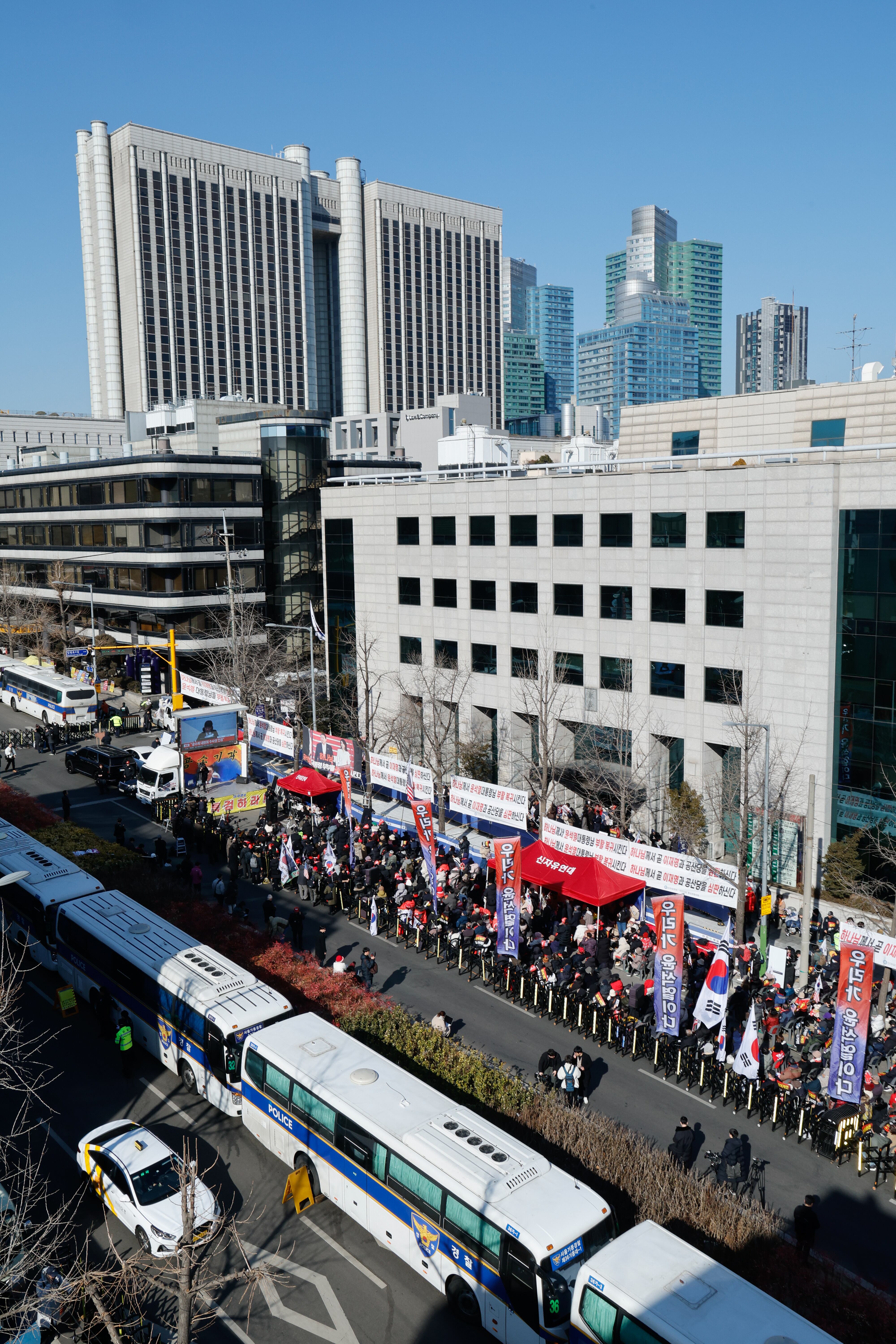윤석열 전 대통령의 12·3 비상계엄 관련 내란 우두머리 등 혐의 1심 선고 기일인 지난 19일 서울 서초구 중앙지방법원 주위의 경찰차벽 앞에서 지지자들이 집회를 열고 있다. /뉴스1