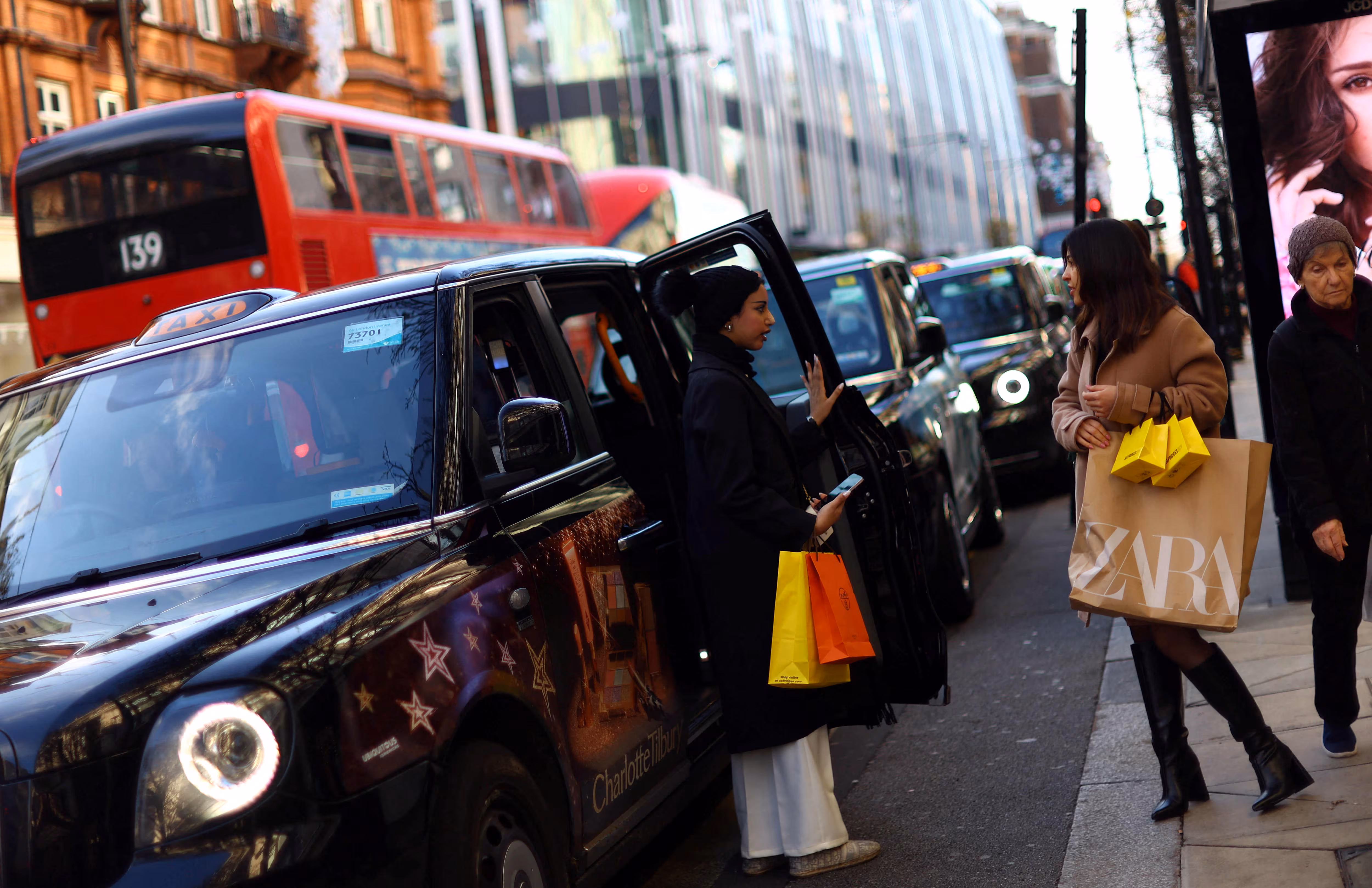 영국 런던 옥스퍼드 스트리트에서 크리스마스 쇼핑객들이 블랙캡 택시를 타고 있다. /연합뉴스