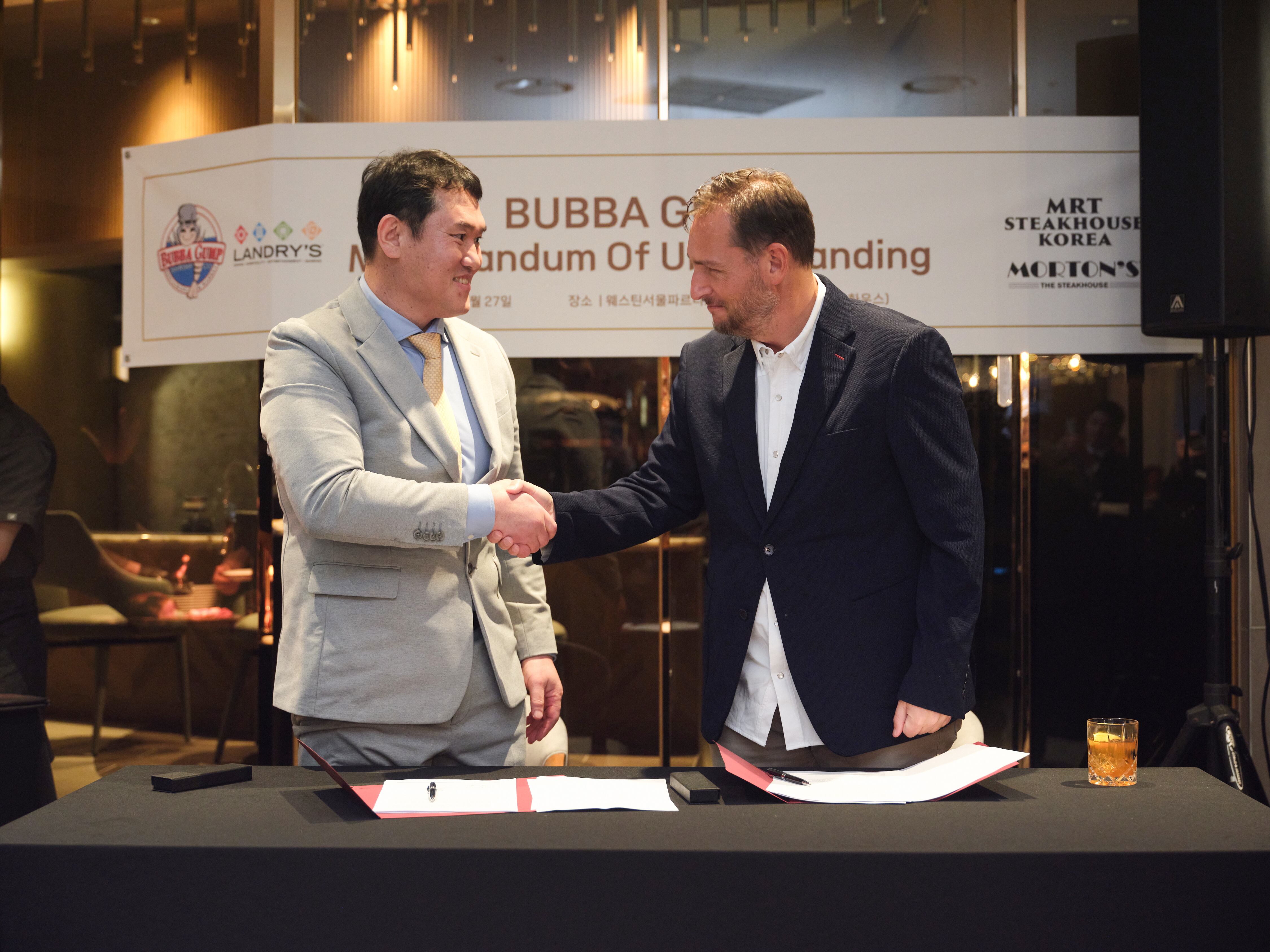 최완일(왼쪽) 엠알티에스케이 총괄대표와 자렛 잉그램 랜드리스그룹 총괄 부사장이 1월 27일  ‘버바 검프 슈림프 컴퍼니(Bubba Gump Shrimp Co.)’의 한국 마스터 프랜차이즈 업무협약(MOU)을 체결하고 악수를 하고 있다. /엠알티스테이크하우스코리아 제공