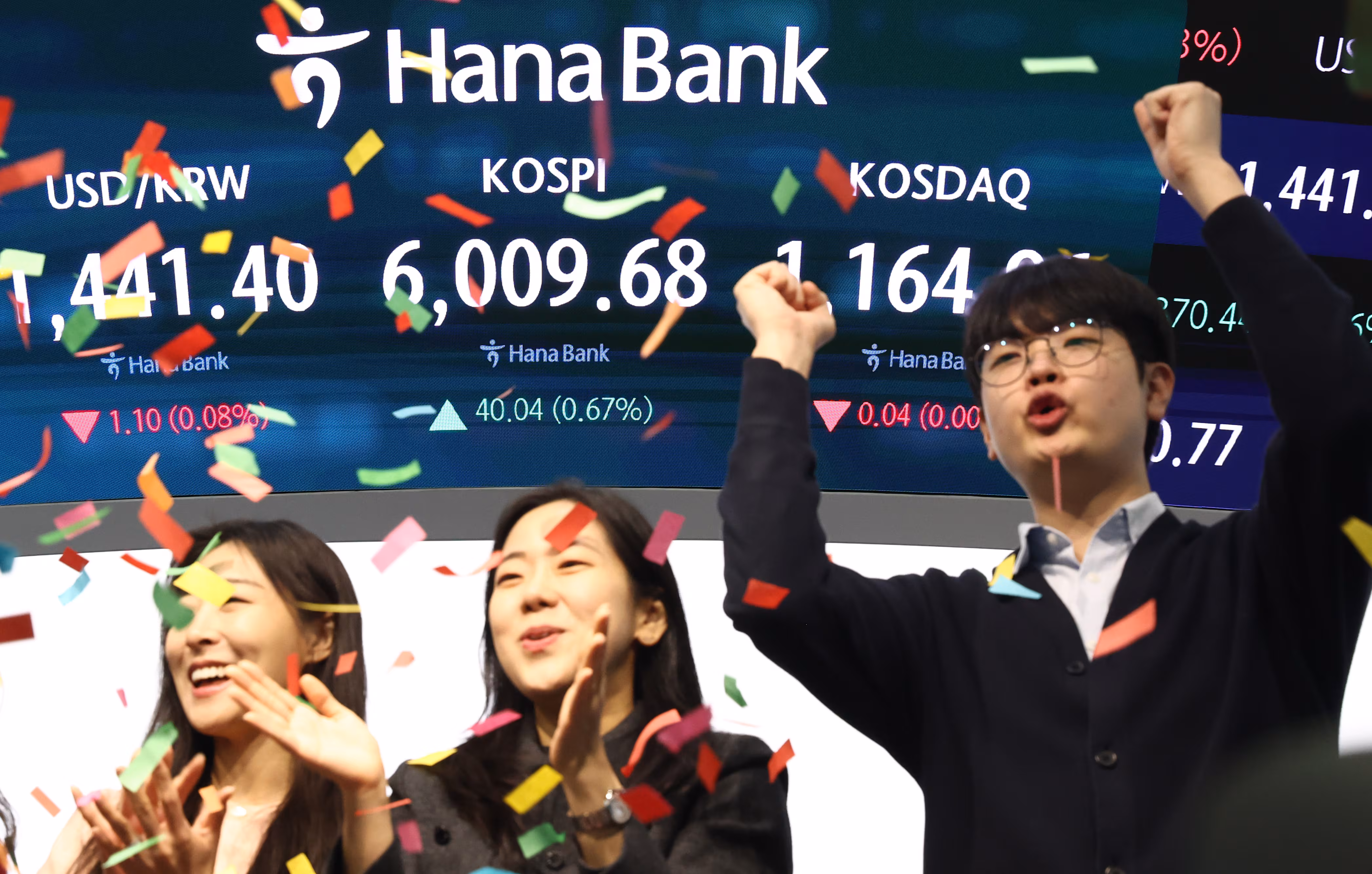 코스피 지수가 6000포인트를 넘어 개장한 25일 오전 서울 중구 하나은행 본점 딜링룸 직원들이 기뻐하고 있다./뉴스1