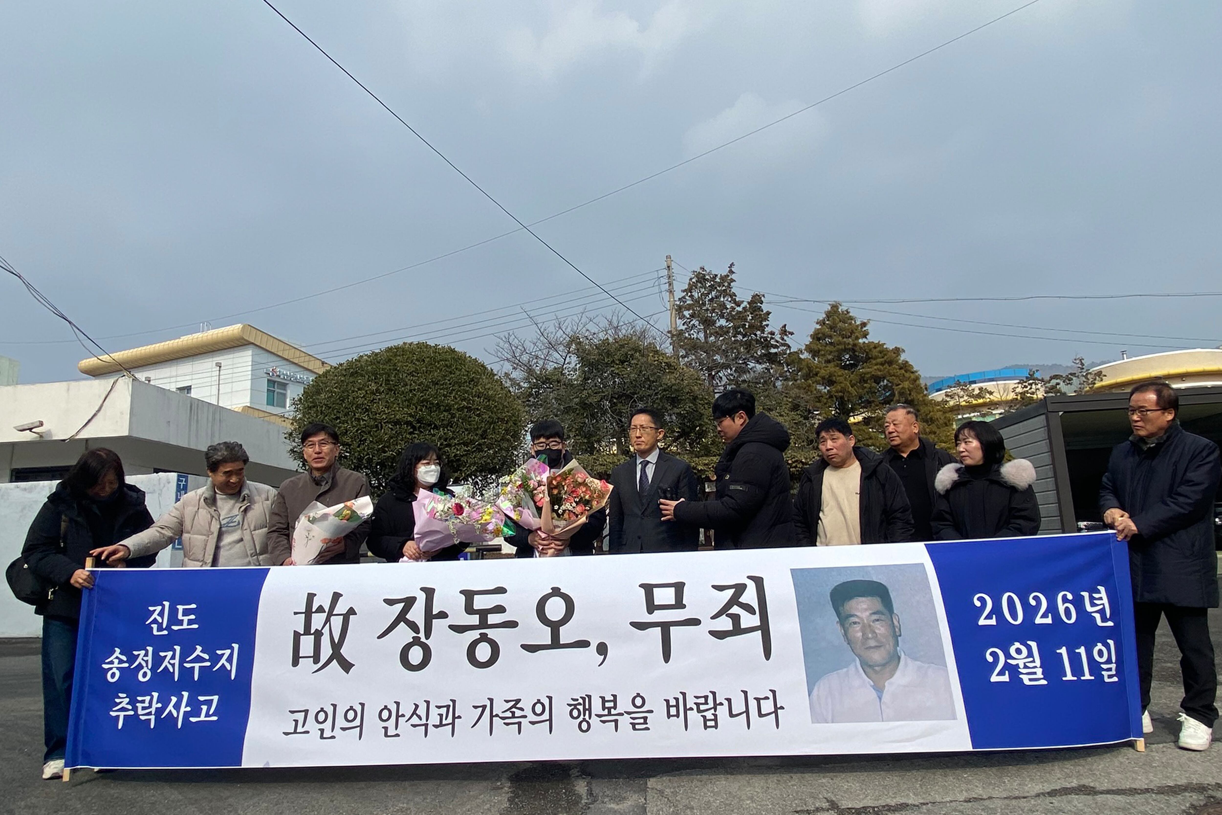 지난 11일 오후 전남 해남군 해남읍 광주지법 해남지원 법정 앞에서 보험금을 노려 아내를 살해한 혐의로 무기징역을 받았던 고(故) 장동오 씨의 유족이 재심 무죄 선고에 따른 축하 꽃다발을 받고 있다./연합뉴스 