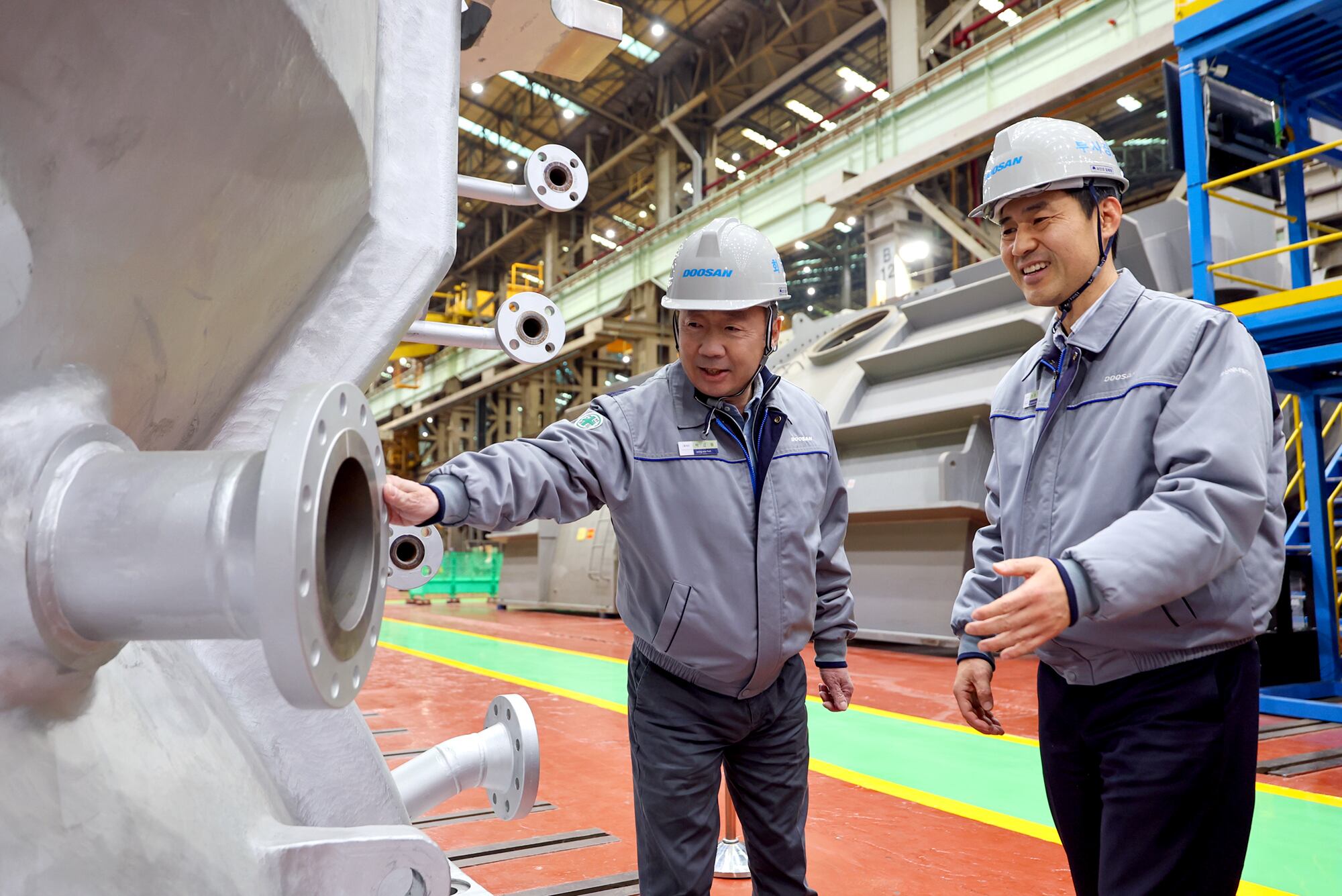 박정원(왼쪽) 두산그룹 회장이 11일 경남 창원 두산에너빌리티 사업장을 방문해 제작 중인 발전용 가스터빈 제품을 살펴보고 있다. /두산그룹 제공