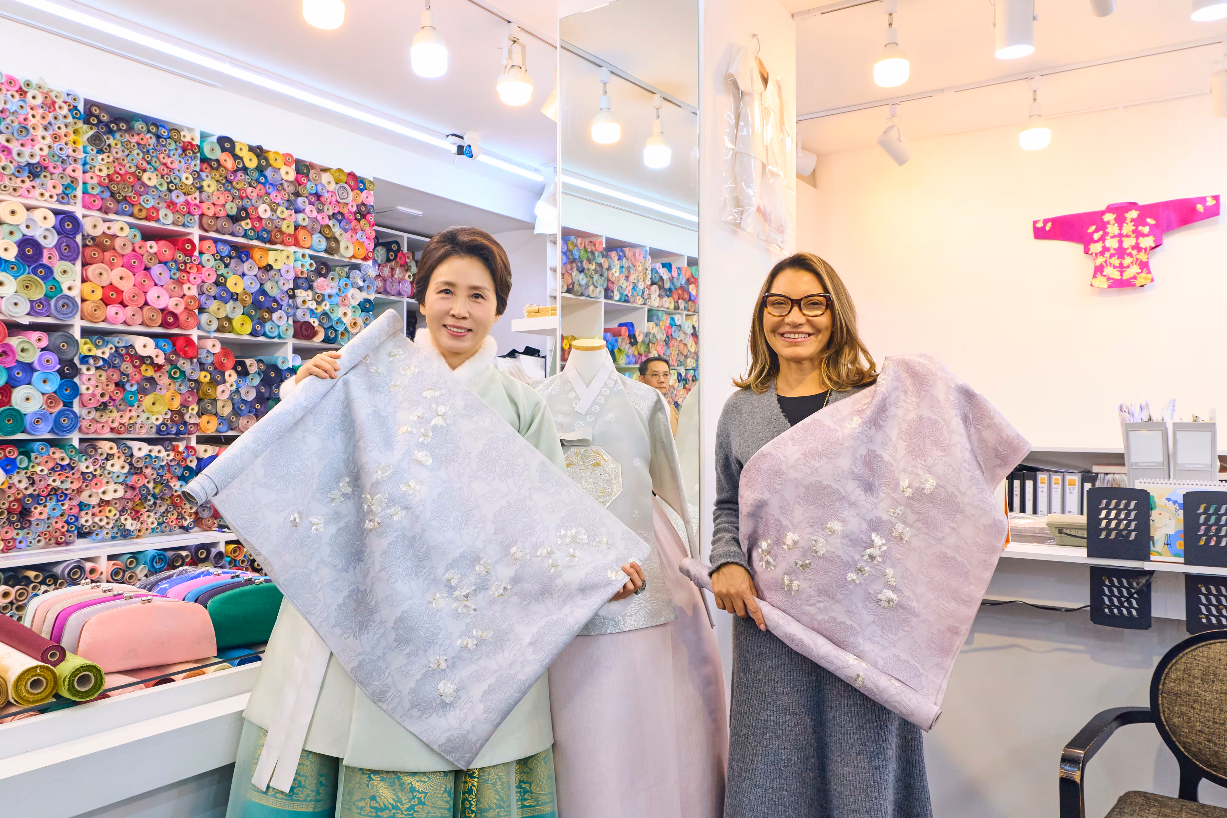 김혜경 여사와 루이스 이나시우 룰라 다시우바 브라질 대통령 부인 호잔젤라 다시우바 여사가 21일 서울 종로구 광장시장의 한 한복가게에서 진행된 친교일정에서 함께 실크원단을 들고 기념촬영을 하고 있다. /청와대 제공