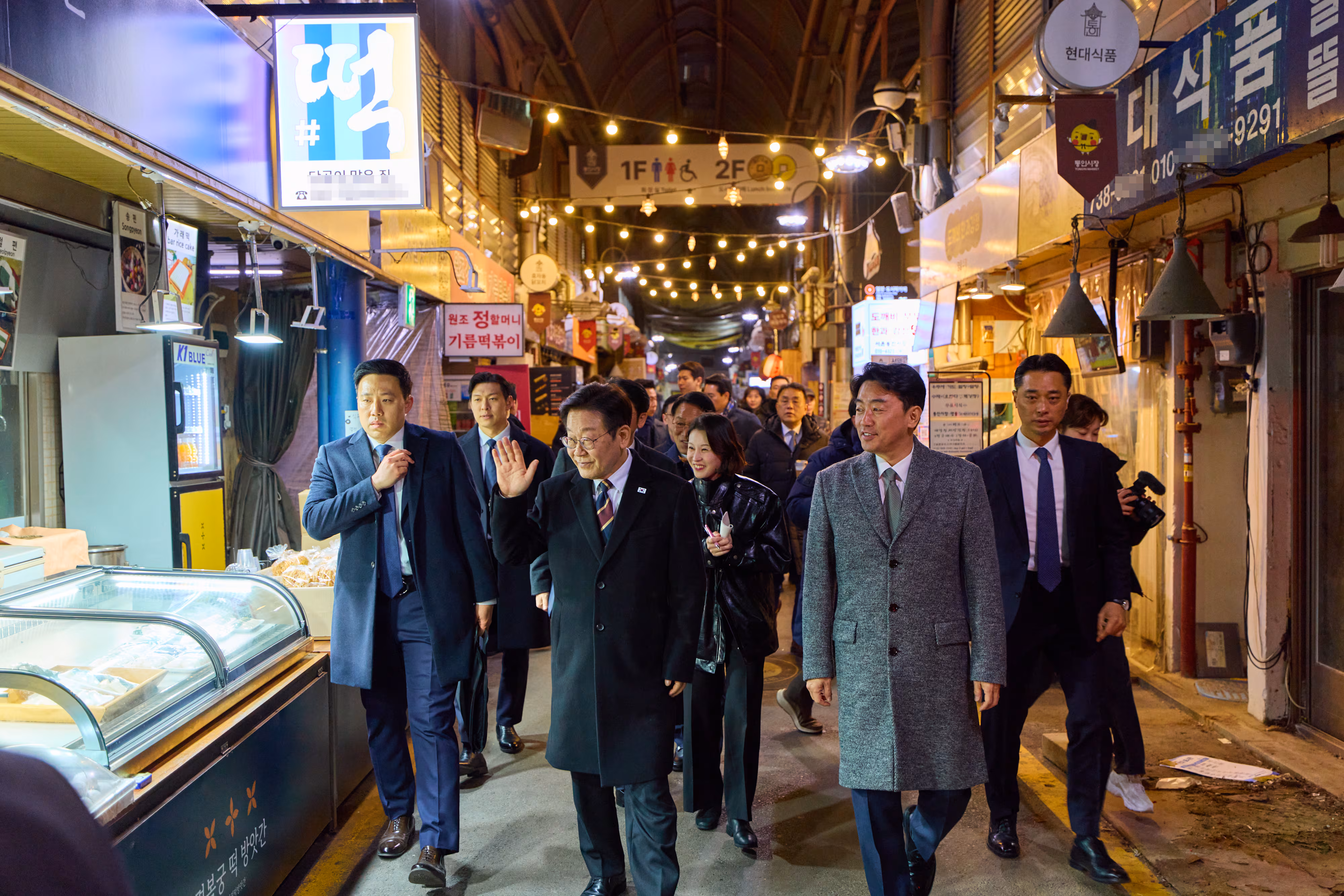 이재명 대통령이 9일 저녁 식사를 위해 방문한 서울 종로구 통인시장에서 상인들에게 인사하고 있다./청와대 제공
