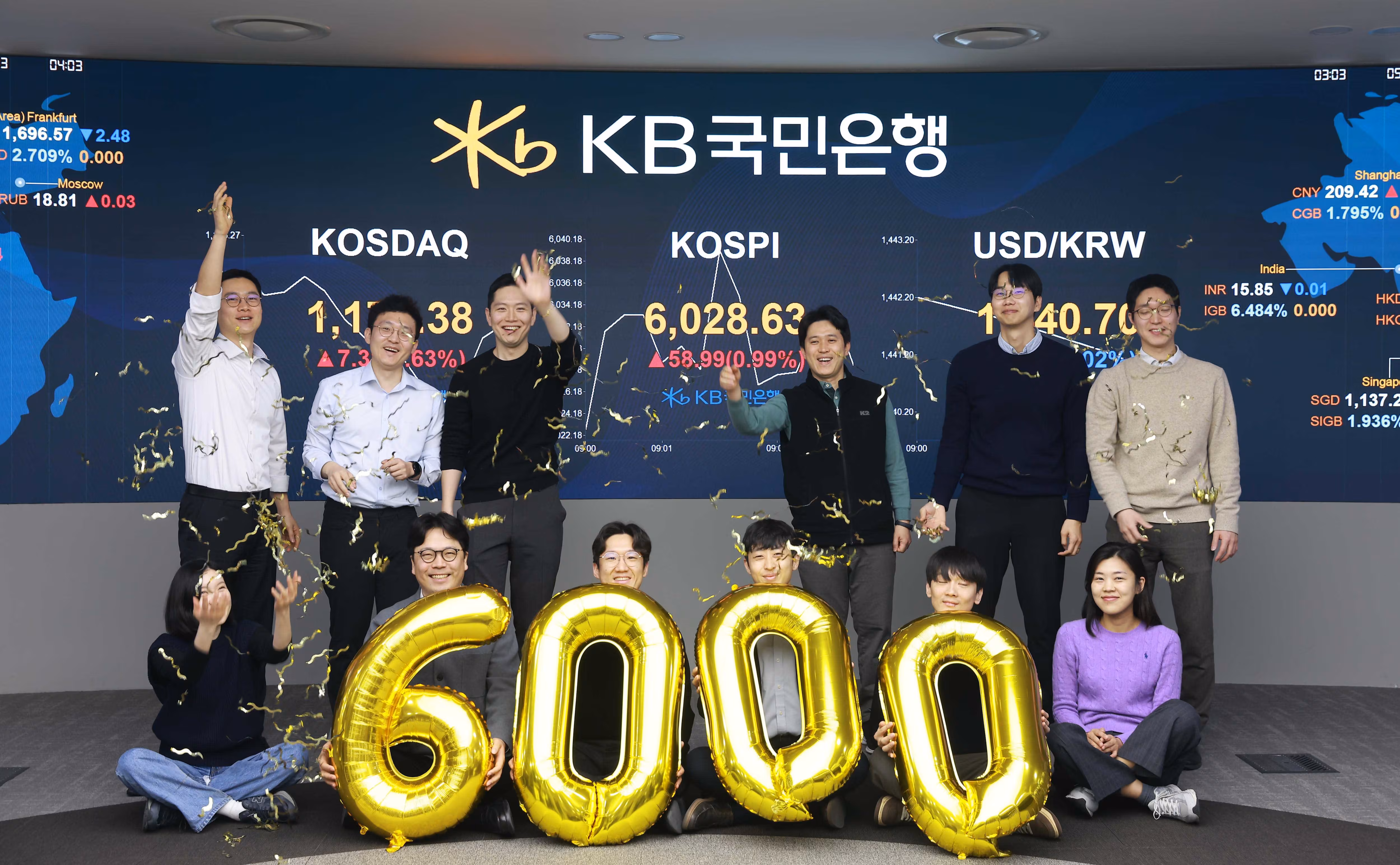 코스피가 장 시작과 함께 6000선을 돌파한 25일 오전 서울 영등포구 KB국민은행 딜링룸에서 직원들이 축하 세리머니를 하고 있다./KB국민은행 제공