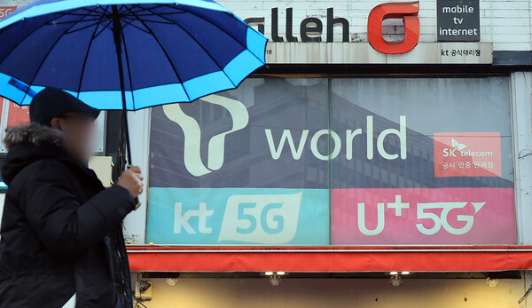 2025년 12월 23일 오후 서울의 한 휴대폰 매장 앞으로 시민이 지나가고 있다. / 뉴스1