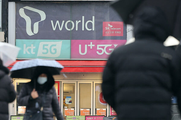 2025년 12월 23일 오후 서울의 한 휴대폰 매장 앞으로 시민이 지나가고 있다. / 뉴스1