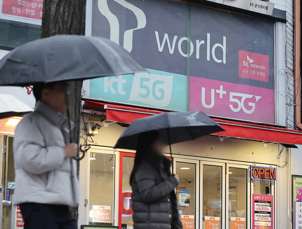 A citizen walks by in front of a mobile phone store in Seoul on the afternoon of Dec. 23, 2025. / News 1