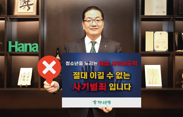 이호성 하나은행장이 서울 중구 하나은행 을지로 본점에서 청소년 불법도박 근절 릴레이 캠페인에 동참하기 위해 '청소년을 노리는 불법 사이버 도박, 절대 이길 수 없는 사기 범죄입니다'라는 메시지를 담은 피켓을 들고 사진을 촬영하고 있다. [사진: 하나은행]