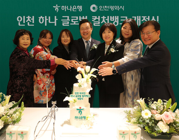 하나은행은 25일 인천 남동구 소재 남동산단금융센터지점 2층에 외국인 주민의 자립과 성장을 지원하기 위한 글로벌 커뮤니티센터 '인천 하나 글로벌 컬처뱅크'를 개점했다. 김미숙 하나은행 중앙영업그룹 부행장(오른쪽에서 세번째), 하병필 인천광역시 부시장(오른쪽에서 네번째) 및 행사에 참석한 관계자들이 축하 케이크를 자르며 기념촬영을 하고 있다. [사진: 하나은행]