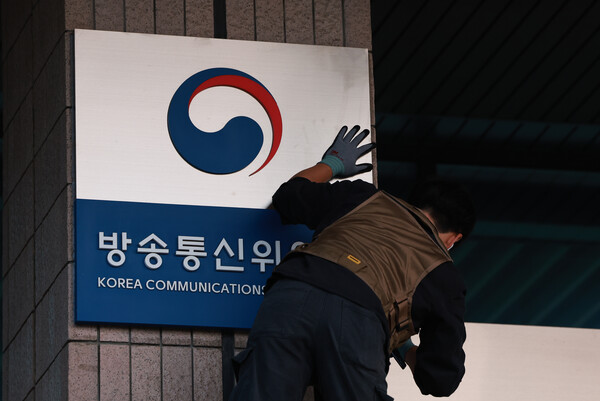 1일 정부과천청사 방송미디어통신위원회에서 관계자들이 방송통신위원회 현판을 철거하고 있는 모습. [사진: 연합뉴스]