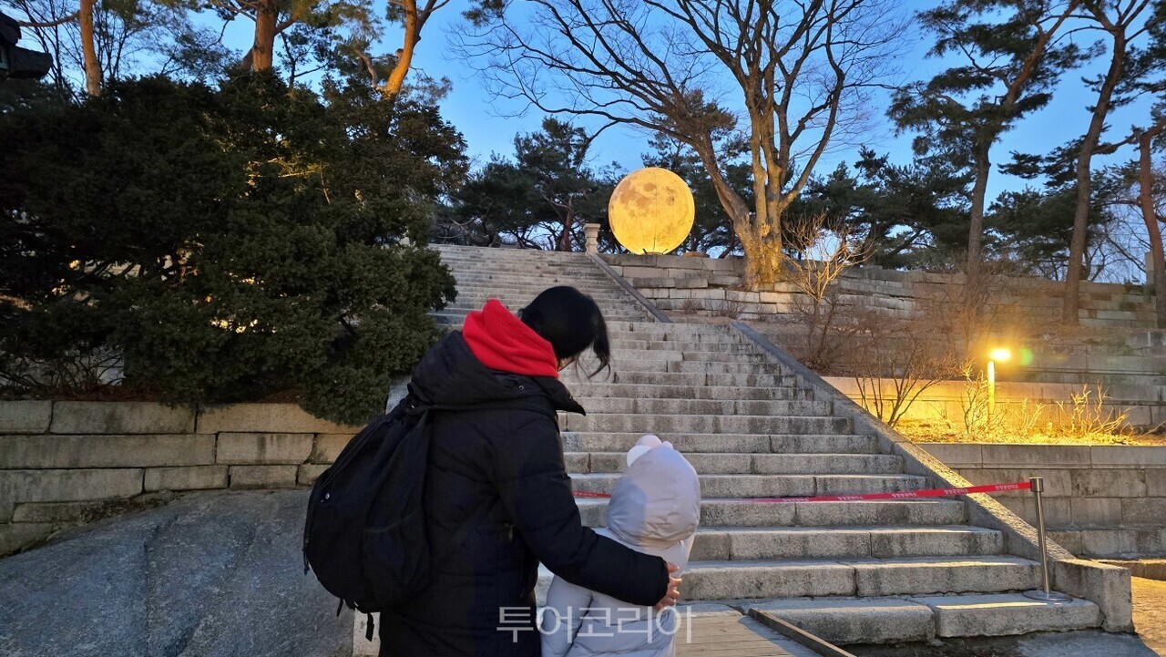 창경궁 정월대보름 행사에서 모형 보름달을 감상하고 있는 관람객/사진-국가유산청