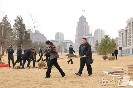 Kim Jong Un, General Secretary of North Korea\'s Workers\' Party, and his daughter Ju-ae planting trees in Saebyul Street / Rodong Sinmun
