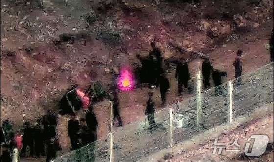 A scene from the Joint Chiefs of Staff’s 2024 report on North Korean military activities, showing troops gathered around a campfire. The Joint Chiefs of Staff stated that North Korea has been conducting operations in frontline areas for about eight months and recently reinforced its forces by several thousand troops. They are installing barbed wire on the top of the barriers along the Military Demarcation Line (MDL) and the Northern Limit Line (NLL), as well as on pre-existing tactical roads north of the MDL. These measures appear to be aimed at completing work planned for this year to demonstrate achievements before the severe winter and the Workers\' Party Plenary Meeting scheduled for late December (Provided by the Joint Chiefs of Staff) 2024.12.23 / News1