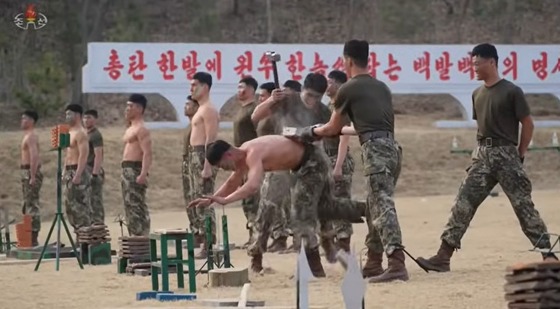 On March 29, Korean Central Television reported on a demonstration performed by combatants in front of Kim Jong Un, General Secretary of the Workers\' Party of Korea. The footage showed them placing their hands on a nail to support themselves while striking a stone slab on their backs with a hammer to shatter it / Capture from Korean Central Television (KCTV)