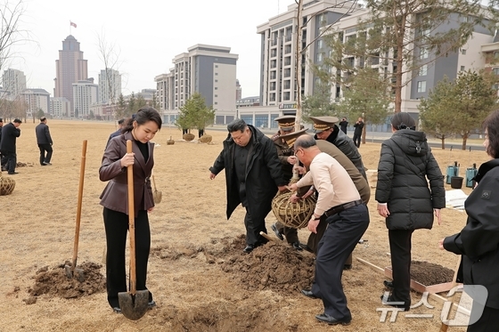 Kim Jong Un, General Secretary of North Korea\'s Workers\' Party, and his daughter Ju-ae planting trees in Saebyul Street / Rodong Sinmun