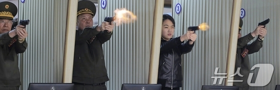 Photo published on the front page of North Korea\'s Rodong Sinmun on Thursday. Ju Ae is seen firing a new pistol alongside high-ranking North Korean officials / Rodong Sinmun