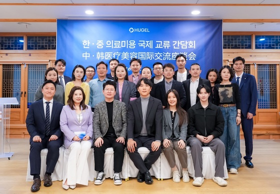 Medical professionals from both countries and Hugel employees, including Vice President Ji Seung-wook (third from left in the front row), pose for a commemorative photo at the Korea-China Medical Aesthetics International Exchange hosted by Hugel. / Courtesy of Hugel