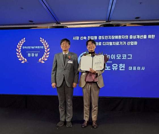 On December 22 of last year, at the Sapphire Ballroom of the Lotte Hotel in Sogong-dong, Jung-gu, Seoul, Lee Mo-kog’s co-CEO, Noh Yu-heon, received the President’s Award from the Korea Institute of Industrial Technology Planning and Evaluation at the 2025 Inter-ministerial Medical Device R&D Awards / Provided by Emocog