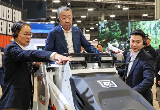 Park Jung-won, Chairman of Doosan Group (center), visited the CONEXPO 2026 site in Las Vegas, U.S., and personally boarded a Doosan Bobcat mini track loader while listening to an explanation from Scott Park, Vice Chairman of Doosan Bobcat (left) / Provided by Doosan Group