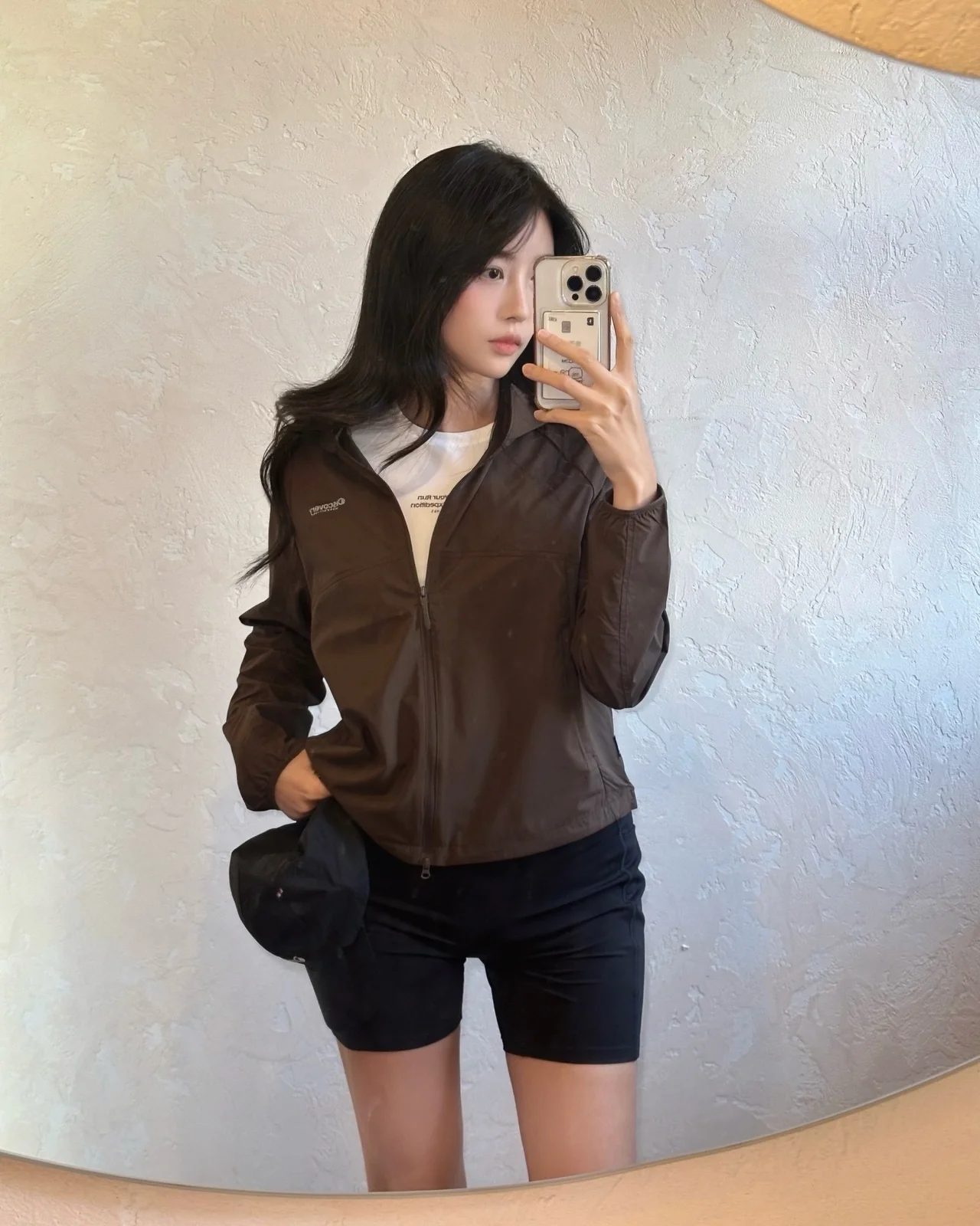 Brown windbreaker + white logo tee + black biker shorts + baseball cap + trail sneakers /Photo: Hong Min-ha Instagram