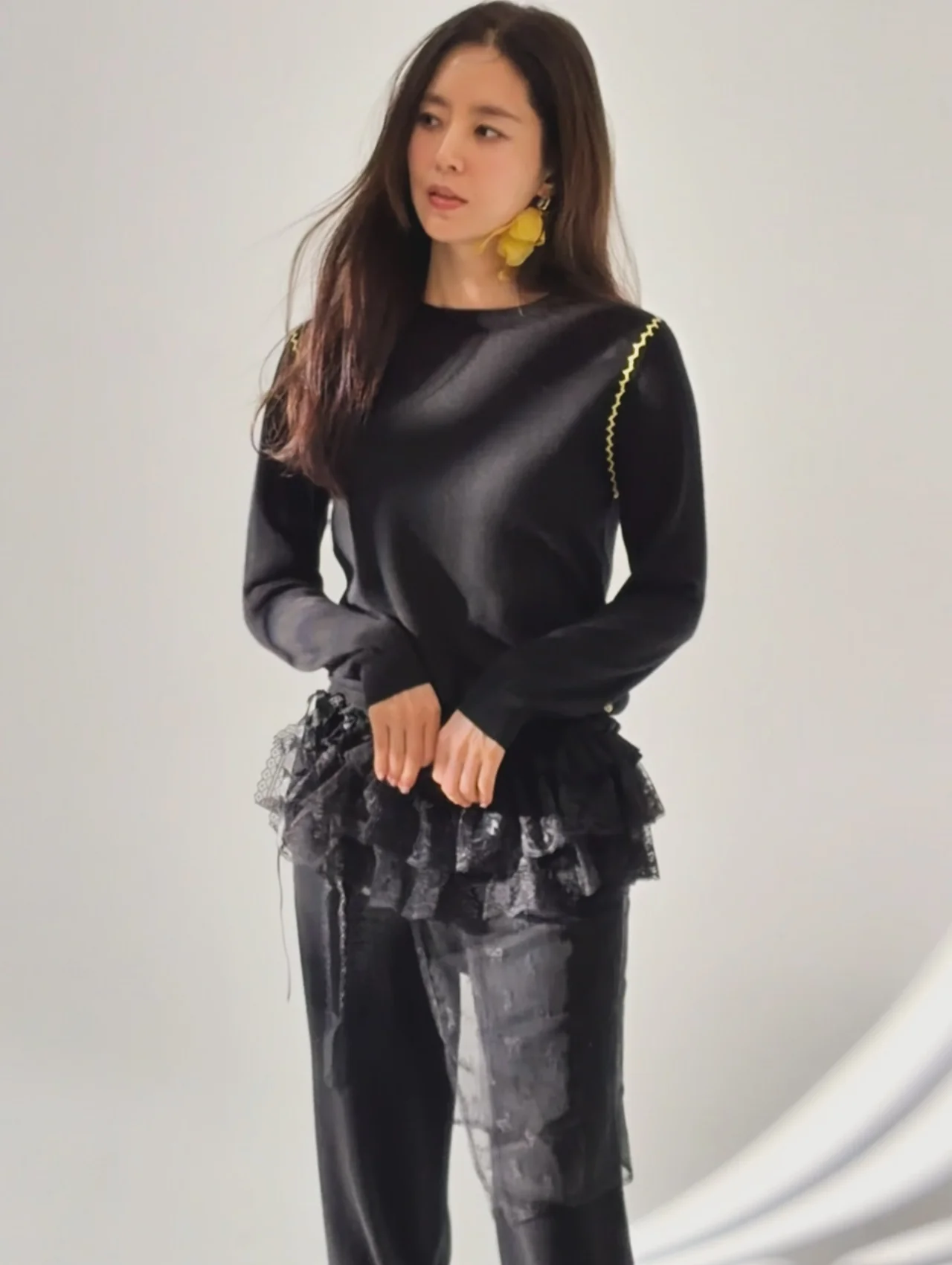 Lace tiered skirt | A lace skirt layered over black pants creates a romantic yet hip silhouette. / Photo: Han Chae-ah Instagram