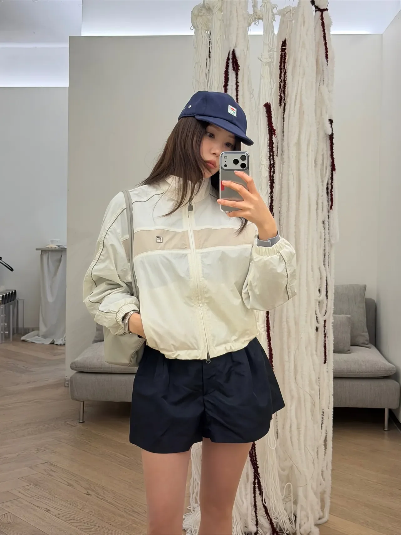 Hyomin pulls off a sporty look in a FILA windbreaker, navy shorts, and a FILA cap. /Photo: Hyomin Instagram