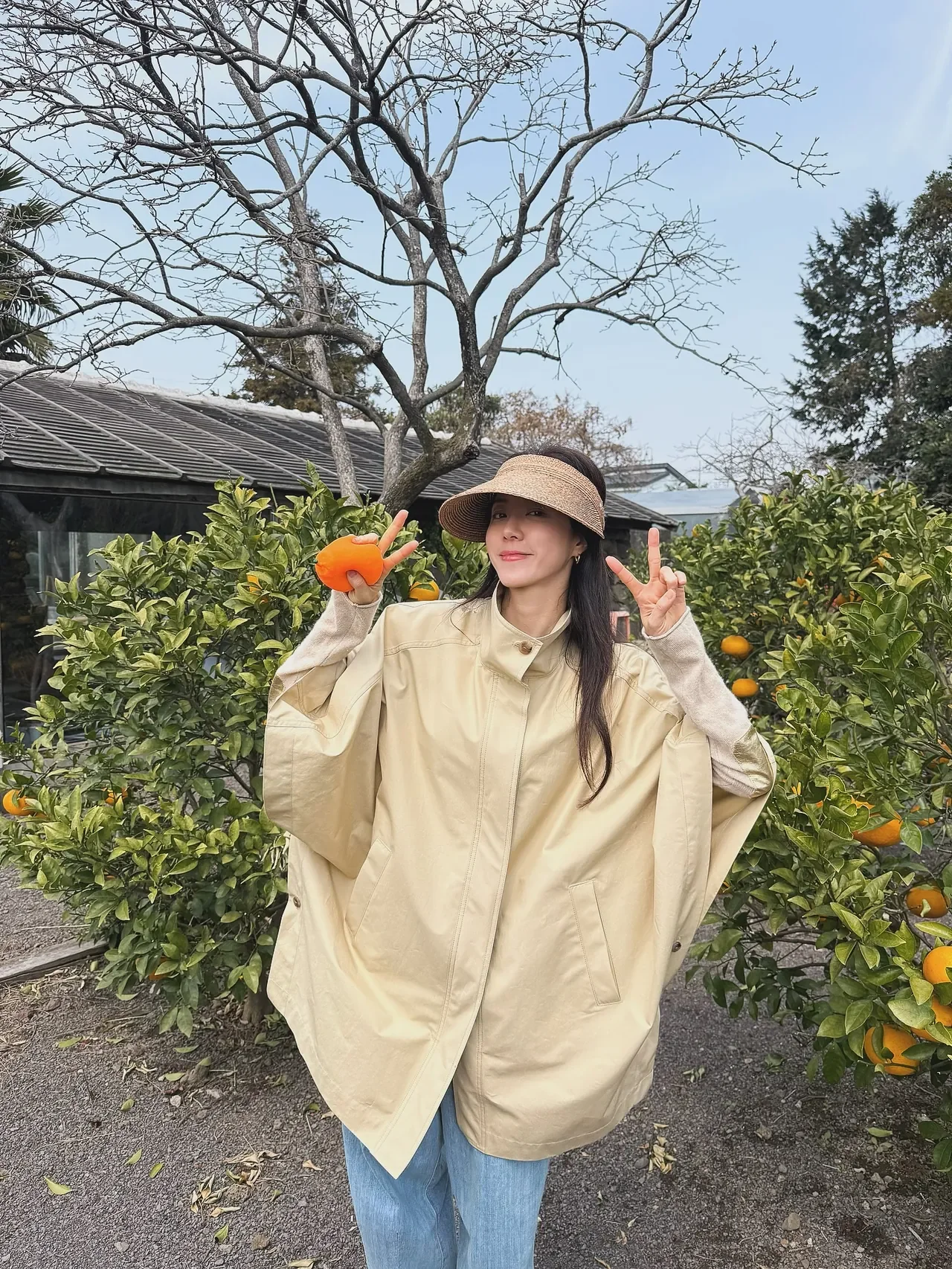 &nbsp;     Park Han-byul shows off a spring travel look in front of a Jeju stone wall, pairing the cape with light-blue wide-leg denim and white sneakers. /Photo: Park Han-byul Instagram