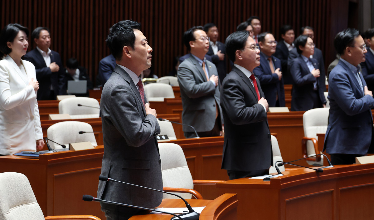 Yonhap NewsPeople Power Party leader Jang Dong-hyuk and Floor Leader Song Eon-seok, together with fellow party lawmakers, salute the national flag at an emergency party meeting at the National Assembly on March 9.