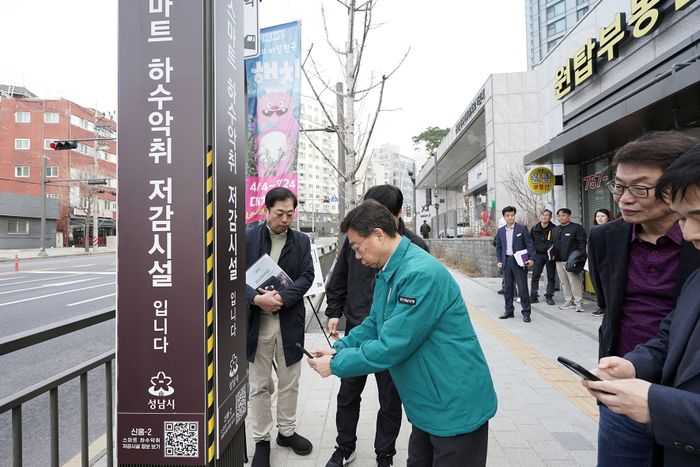 신상진 성남시장이 악취 농도 측정 결과를 확인하기 위해 신흥2동 스마트 하수 악취 저감시설에 부착된 큐알(QR)코드를 스마트폰으로 스캔 중이다. ⓒ성남시 제공