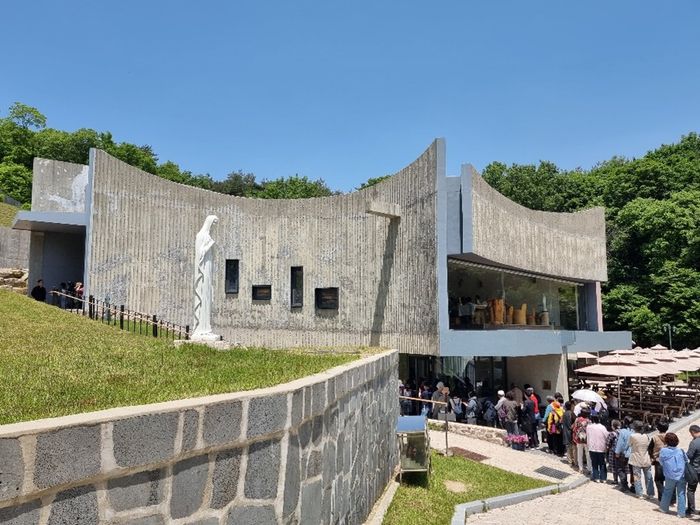ⓒ성당 건물과 점심 식사를 하기위해 줄을 서서 기다리는 순례객